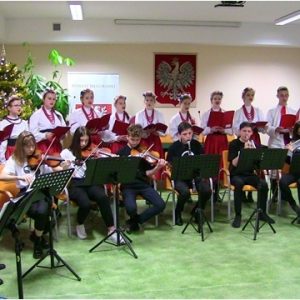 Na zdjęciu grupa śpiewa i gra tradycyjne polskie kolędy na spotkaniu opłatkowym Samorządu Powiatowego w Biłgoraju.